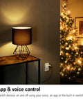 Matter Over Thread Smart Plug Pack With App And Voice Control in wall socket near lamp and Christmas tree.