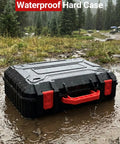 Waterproof Hard Case For Starlink Mini Kit in black with red handle, placed in a puddle in a forest setting.