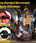 Worker moving 14000 CFM Heavy Duty Industrial Drum Fan Built Tough For Real World Jobs through warehouse with smooth wheels and handle.