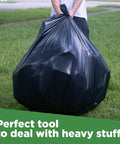 Person holding a 95 Gallon Extra Large Trash Bags 61x68 Inches 1.2 Mil Thick Beefy Heavy Duty Contractor Bags For Outdoor Waste Storage Landscap
