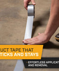 Person applying Heavy Duty Waterproof Duct Tape Grey 30 Yards By 2 Inch 10 Roll Pack No Residue Adhesive on concrete floor
