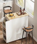 Farmhouse Mobile Kitchen Island Cart With Slick Rolling Lockable Casters And Front Glass Cabinet Plus Roomy Gear Hauler Drawer And Three Tier Spice Shelf For Weekend Cookoffs, wooden top with fruits and drinks, side shelves.