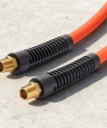Heavy Duty 1/2 Inch By 100 Foot Air Compressor Hose With Solid Brass Fittings kink free ends on a concrete surface.