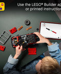 Child assembling Ford Bronco Technic Off Road SUV Building Kit For Kids 9 And Up with tablet instructions on a table
