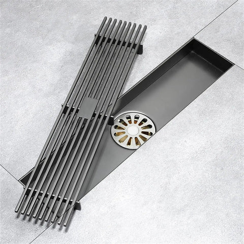 Heavy Gauge Stainless Steel Rectangle Shower Drain With Tile Insert Grate Removable Cover Anti Clog Hair Catcher For Smooth Quick Flow Rust Proof Bathroom Setup, top view with black grate and drain visible.