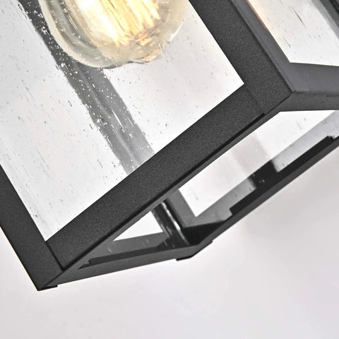 Close-up of Sleek Transitional 1 Light Textured Black Outdoor Wall Sconce with Clear Seedy Glass Downlight showing bulb detail