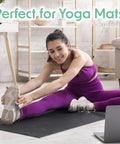Woman stretching on yoga mat in home gym using Plant Based Gym Wipes For Fitness Equipment Clean And Sanitize With Lemongrass