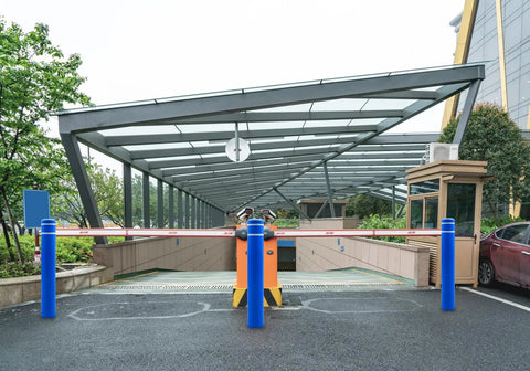 Tough As Nails Blue Safety Bollard Cover 6 Inch Wide 46 Inch Tall High Visibility Reflective Tape at parking lot entrance.