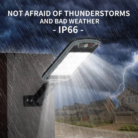 Lit Up Solar Flood Lights Outdoor With 168 LED IP66 mounted on wall in rain, eight-sided design illuminating stormy neighborhood