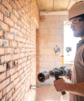 SDS Plus carbide-tipped rotary hammer core bit attached to drill, used by a construction worker in safety gear