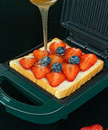Compact Electric Sandwich Maker And Grill Press For Perfect Grilled Cheese with fruit and honey on bread.