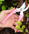 Hand holding Rugged Pro Grade Garden Flower Shears Pruning Scissors Six Point Nine Inch High Carbon Steel Sharp Plant Cutter