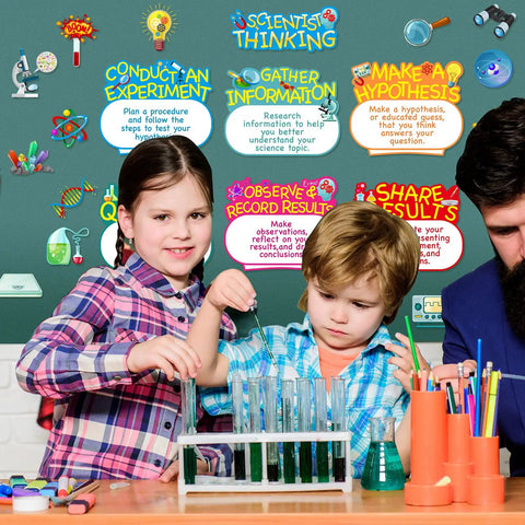 Children conducting experiment with Science Bulletin Board Set With Colorful Lab Cutouts And Scientist Posters in classroom background.