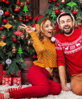 Kick Start Your Festive Craft Game With This 20 Piece Diy Christmas Tree Ornament Woodturning Kit Featuring Smooth Multicolored Wooden Tubes That Are A Straight Up Game Changer For Making Hella Awesome Xmas Decor And Tree Hangings. A couple celebrates near a decorated Christmas tree with colorful ornaments.