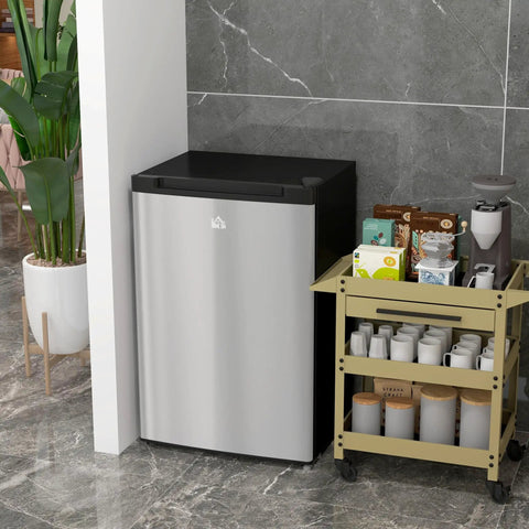 Compact Upright Freezer With 3 Cu Ft Capacity And Reversible Silver Door Featuring Easy Turn Thermostat For Small Kitchens Apartments And Dorm Rooms next to a storage cart.