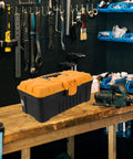 Rugged Multilayer Plastic Toolbox With A Secure Snap Latch And Spacious Yet Compact Shape on a workbench in a garage.