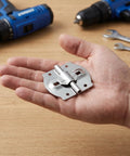 Hand holding 4Pcs Iron Adjustable Angle Hinges For Suitcase And Jewelry Box Concealed Mounting Cabinet Replacement Hinges Dual Shaft Metal Box Hinges