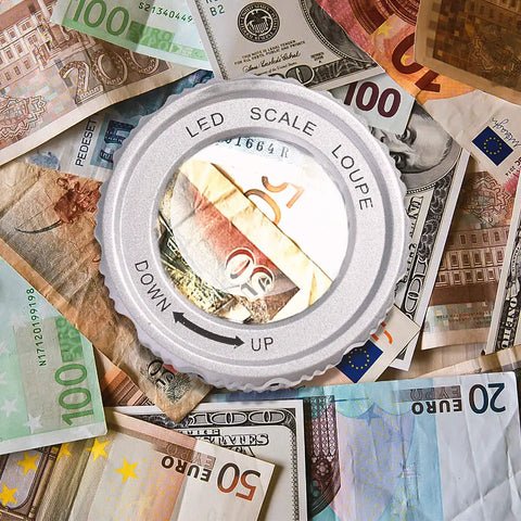 30X Loupe Magnifier With Adjustable Focal Length And Foldable Design inspecting banknotes, featuring LED scale and lens.