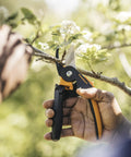 PowerGear2 Pruning Shears With Rolling Handle trimming branch in garden, UltraBlade coating visible
