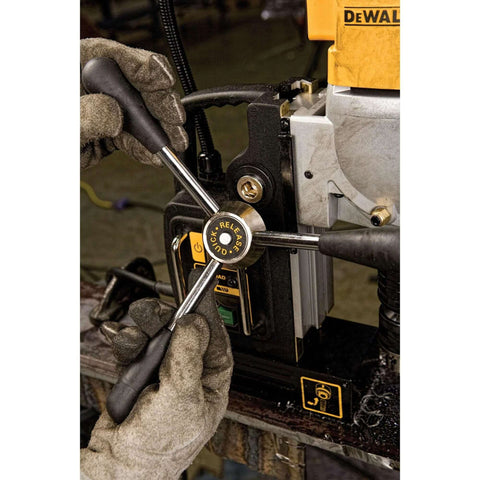 DEWALT drill press with orange housing and black frame; gloved hands adjust quick-release handle.