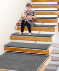 Child on stairs with Grey Stair Tread Carpet Runner Set With Adhesive Backing And Nonskid Grip For Easy Install 14 Plus 1 Pieces