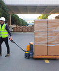 Heavy Duty 3300 Lb Electric Pallet Jack With Smart Control Handle And Fast Lifting moving a pallet of boxed cargo outdoors.