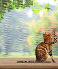 Cat sitting by a Balcony Pet Net For Cats And Dogs, 16.5 Ft By 2.5 Ft Anti Fall Mesh Fence Netting on a wooden patio