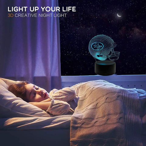 Football Helmet Shape 3D LED Night Light With Optical Illusion on a bedside table in a dimly lit bedroom scene.