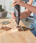 Dremel EZ406-02 rotary tool with 1.5-inch cut-off wheel, front view cutting metal on a wooden workbench.