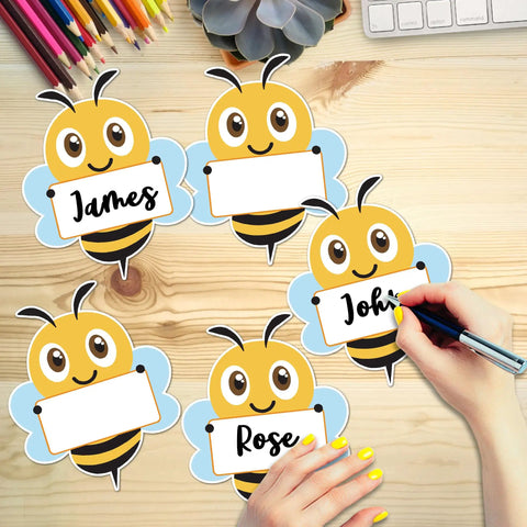 Bee Cutouts For Classroom Decorations 50 Pack Name Tags And Desk Nameplates Cute Bee Style Labels on a wooden desk surface.