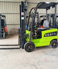 Heavy Duty Electric Forklift With Hydraulic Joystick And Swappable Attachments For Rock Solid Warehouse Operations And Harbor Container Handling No Sweat Industrial Lift Gear Built To Last in green, showcasing its robust design and dual forks.