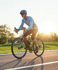 Cyclist riding a road bike at sunset, equipped with Two Pack 700x35C 38C 40C 42C 43C Bike Tubes With AV48mm Schrader Valve Inner Tube 700C