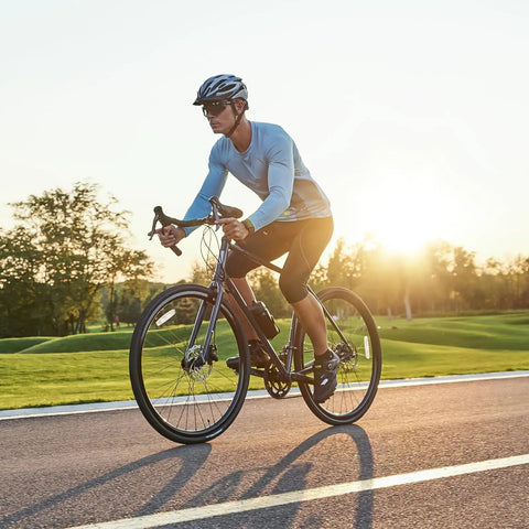 Cyclist riding a road bike at sunset, equipped with Two Pack 700x35C 38C 40C 42C 43C Bike Tubes With AV48mm Schrader Valve Inner Tube 700C
