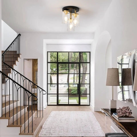 Modern foyer with three-light semi flush mount ceiling light fixture with dope clear glass cylinder shades in gold finish.