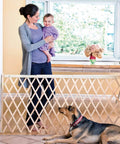 Mother holding baby near Expansion Walk-Thru Baby Gate For Wide Open Spaces Fits 24 To 60 Inches Openings 32 Inches Tall Hardware Mount