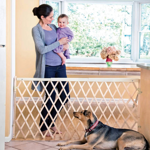 Mother holding baby near Expansion Walk-Thru Baby Gate For Wide Open Spaces Fits 24 To 60 Inches Openings 32 Inches Tall Hardware Mount