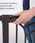 Close-up of a hand operating the secure lock indicator on a Tall And Wide Baby Gate For Doorways With Easy Install No Drilling and Pressure Mount Decor Friendly Design.