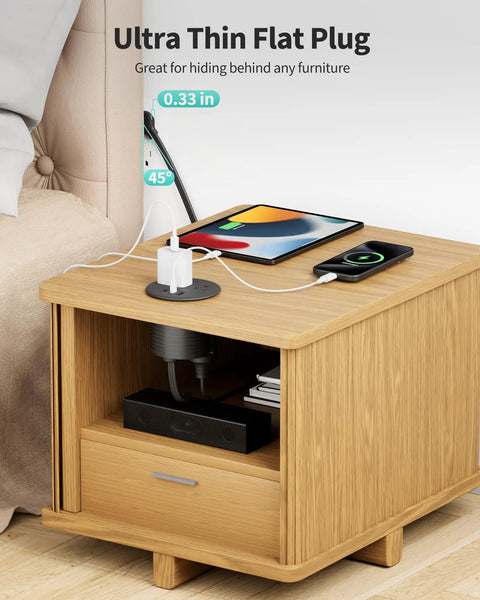 Dual Sided Desk Grommet Power Strip With Four AC Outlets And Three USB Ports Including Two Type C Connectors on wooden nightstand.