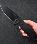 Hand holding VG10 Steel Fixed Blade Tactical Knife With Ergonomic Micarta Handle And Kydex Sheath on a textured surface