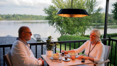 Couple dining outdoors with Hangin Infrared Outdoor Heater With LED Light And Remote 400W And 1500W Heat Settings