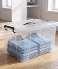 Heavy Duty 90 Quart Clear Storage Bins With Lids Six Pack, see-through container holding stacked blue shirts on wooden floor.