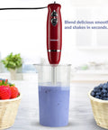 Heavy Duty 4 In 1 Immersion Hand Blender With Rock Solid 500W Motor And Two Speed Settings Featuring Splash Control Tech And Versatile Attachments For Your Daily Kitchen Hustle blending smoothie in measuring cup.