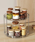 2 Tier Lazy Susan Turntable Organizer For Narrow Cabinets, showcasing clear plastic, two-tier design with spice jars on kitchen countertop.