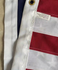 Close-up of brass grommets and sewn stripes on Outdoor 3x5 Foot American Flag Built Tough Deluxe Heavy Duty Spun Polyester Tear Resistant Waterproof All Weather High Wind USA Flag With Embroidered Stars Sewn Stripes Brass Grommets