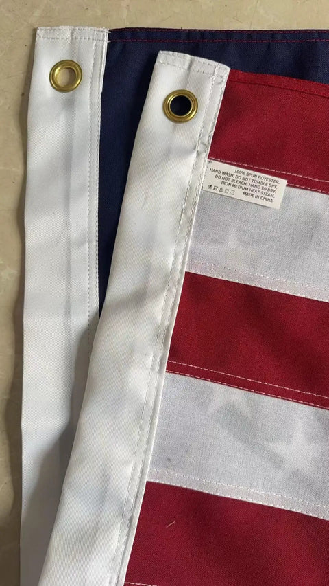 Close-up of brass grommets and sewn stripes on Outdoor 3x5 Foot American Flag Built Tough Deluxe Heavy Duty Spun Polyester Tear Resistant Waterproof All Weather High Wind USA Flag With Embroidered Stars Sewn Stripes Brass Grommets