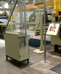 Industrial factory setting with machinery, control panels, and ceiling cranes visible, no specific products shown.