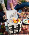 Desert Cowboys Insulated Lunch Bag with shoulder strap open on picnic blanket, holding snacks and drinks