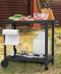 32x20IN Double Shelves Grill Table Movable Outdoor Grill Cart For Griddle And Pizza Oven Patio Kitchen Prep Table For Parties BBQs And Outdoor Cooking Durable Weatherproof Metal Stand With Easy Cleanup showing in garden setting with knives, propane tank, and ingredients on top.