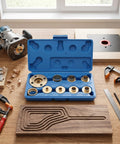 Kickass 11 Piece Brass Router Bushing Kit With Universal Lock Nuts And Heavy Duty Case open on wooden table with router and tools.