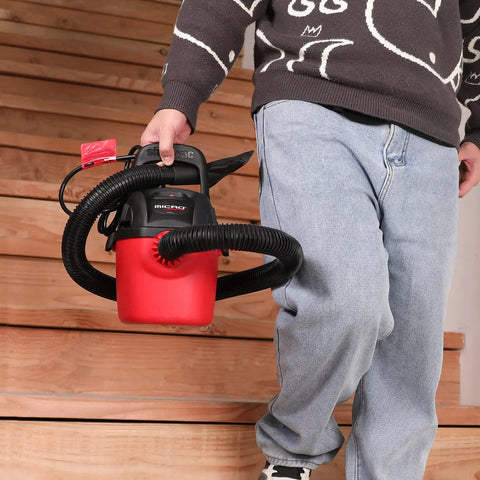 Man carrying a Micro Wet Dry Vacuum Portable 1 Gallon Vac With Collapsible Handle And Wall Bracket 1 HP Peak Power Includes 4 Foot Hose